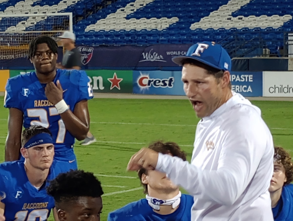 Frisco defensive lineman Lauryn Pendergraph (standing at left) listens to Raccoons' head coach Jeff Harbert following Frisco's 30-7 win against Sherman on Sept. 28, 2023.